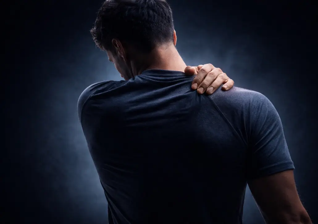 Mann greift sich mit der Hand an den Nacken bei Beschwerden.